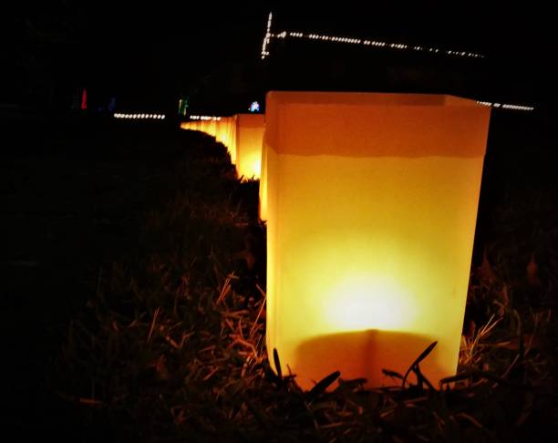 Glowing Luminaria "Paper Bag" Decorations on a Lawn for Christmas -- Night stock photo