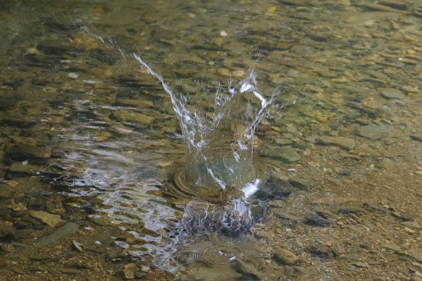 istock bursts from a stone thrown into the water 894632612