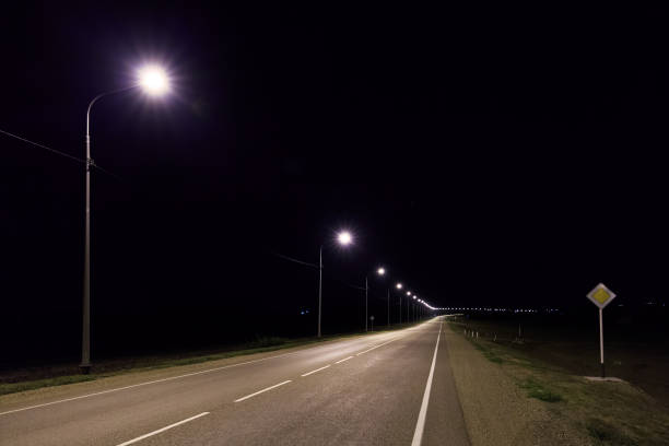 istock Lonesome asphalt road at night in summer 894638998