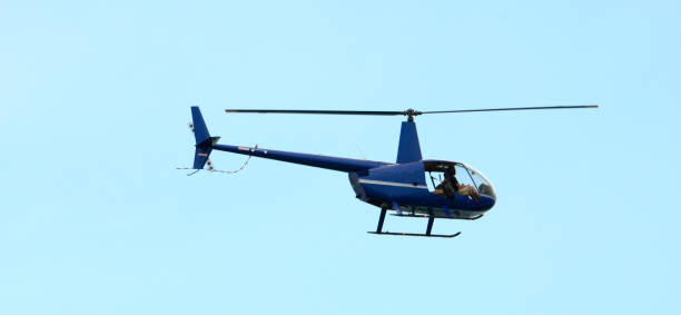 istock Mid-Air Flight of a Helicopter Against a Blue Sky 894647598