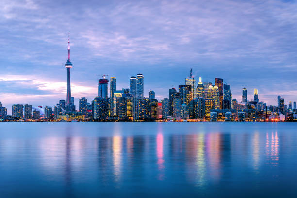 Toronto Skyline under Cloudy Sky at Dusk Spectacular View of Downtown Toronto under Cloudy Sky at Dusk with Lights Reflecting in Water. Ontario, Canada. toronto stock pictures, royalty-free photos & images