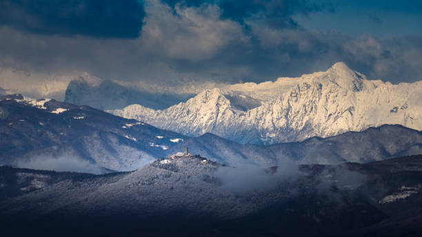 Beautiful view of snow capped Julian Alps with Sveta Gora mountain in the foreground Panoramic shot of winter landscape with Julian Alps in the background, Slovenia primorska white sport nature stock pictures, royalty-free photos & images