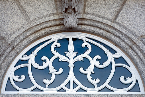 Above front door glass and cast iron. Fanlight, architectural feature.Stone wall. Galicia, Spain.
