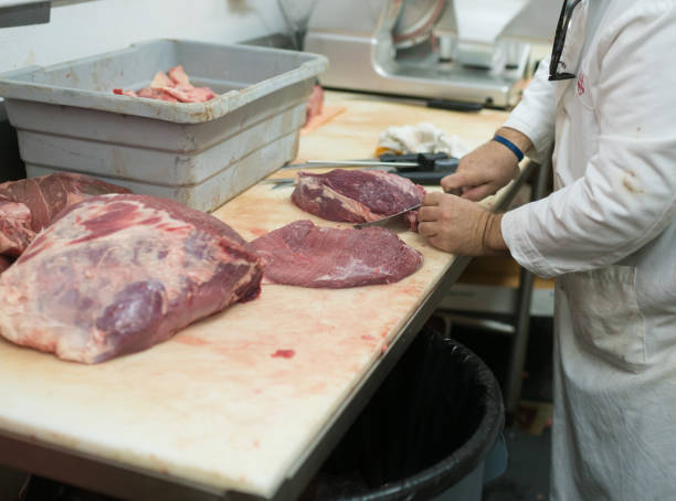 istock Butcher cutting top round steak 894662142