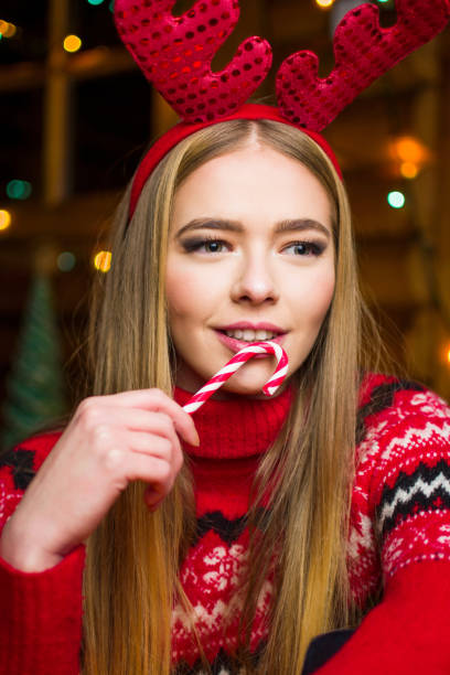 istock Girl with red lollipop in festive decorated environment 894662198