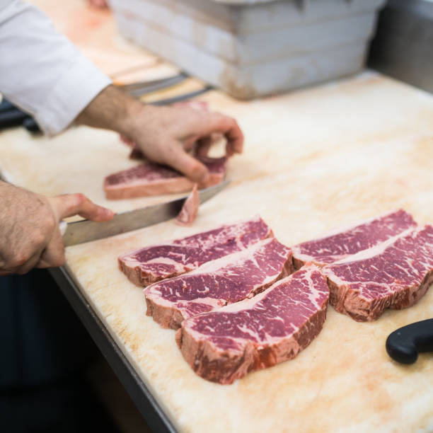 istock Butcher cutting a new York steak 894662510