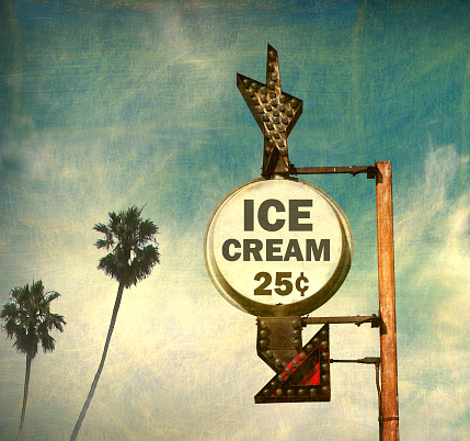 aged and worn ice cream sign with palm trees