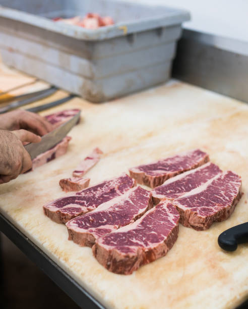 istock Butcher cutting a new York steak 894662592