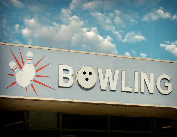 Red bowling ball hitting pins in the bowling alley before blue background. Horizontal composition with copy space. Bowling concept.