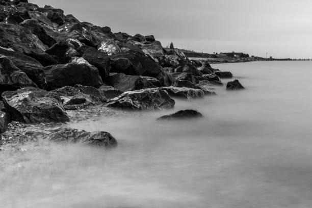 istock Waves crash over rocks on beach in Essex 894670784