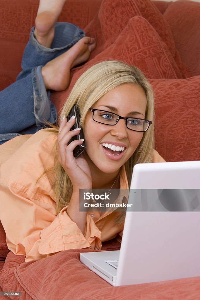 Belle souriante jeune fille blonde sur téléphone portable et ordinateur portable - Photo de Adulte libre de droits