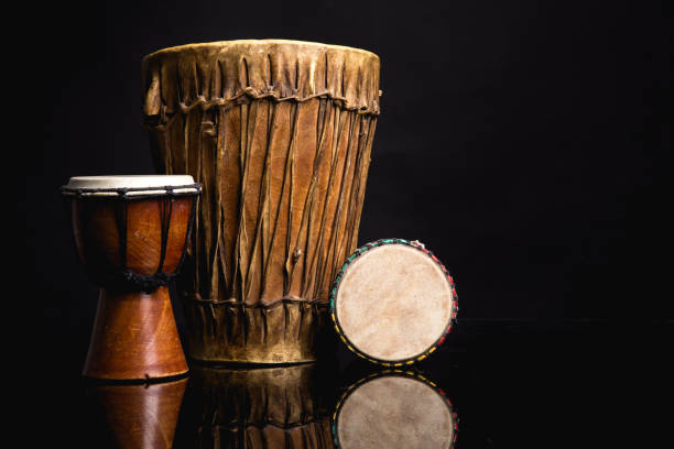 drei alte handgefertigte djembe trommeln isoliert auf schwarz - rhythmusinstrument stock-fotos und bilder