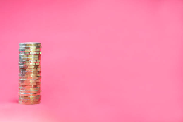 monedas de libra apiladas sobre un fondo rosa - one pound coin coin uk british currency fotografías e imágenes de stock
