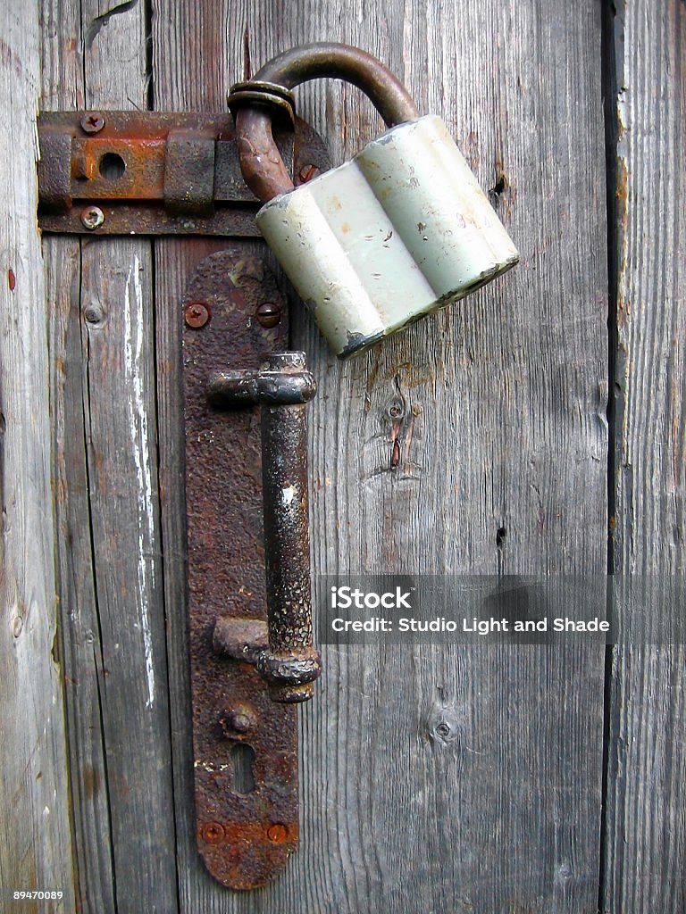 Locked since long ago Old rusty door lock on a wooden door. Ancient Stock Photo