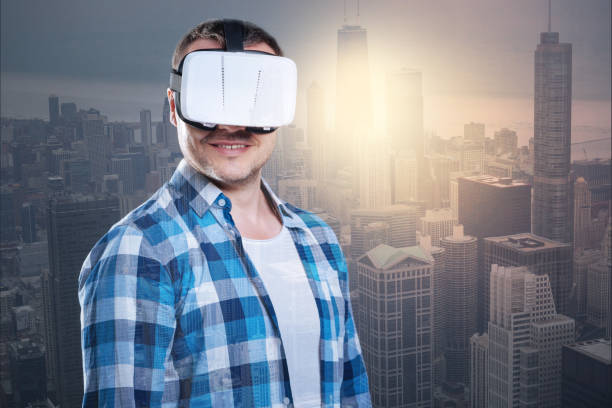 istock Smiling positive man wearing virtual reality glasses 894702378