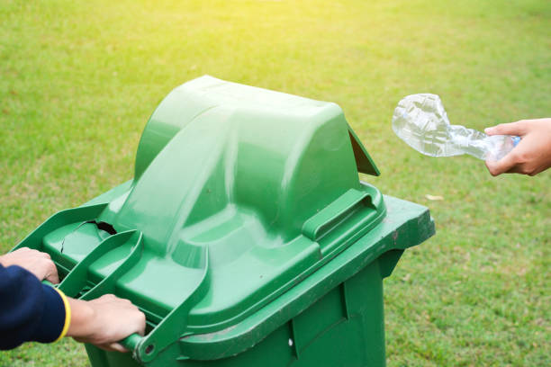 istock Volunteers With Garbage Bin Cleaning Grassy Field 894707624