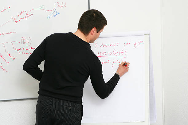 Estudiante escribe sobre la placa en un seminario - foto de stock