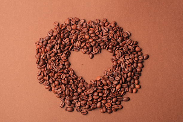 Coffee beans heart over brown background stock photo