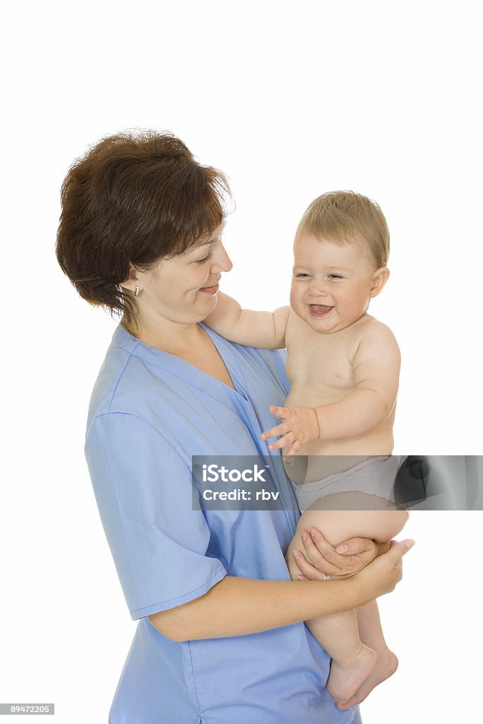 Medico tenendo piccolo bambino sorridente isolato - Foto stock royalty-free di Bebé