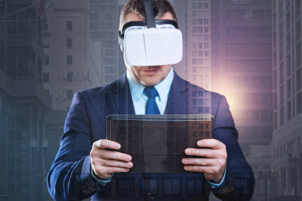 istock Focused millennial gentleman with touchpad trying on virtual reality goggles 894730130