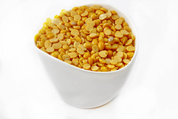 Yellow lentils or Arhar daal in a container on white background