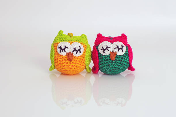 istock Two colorful handmade knitted owls placed on a white background 894736414