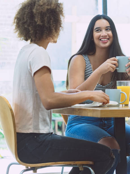 istock Happy lesbian couple talking and eating breakfast at dining table 894741270