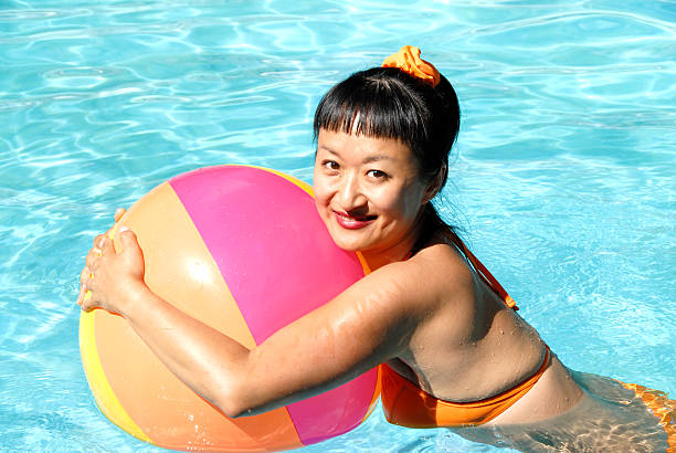 Beach ball floating in a blue swimming pool. Summer background.
