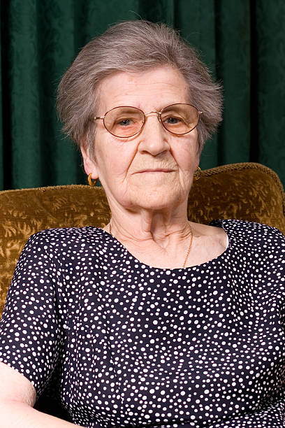 Elderly Woman wearing sunglasses with a grin.