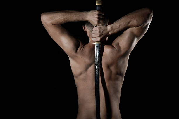 Silhouette of a young man with sword stock photo