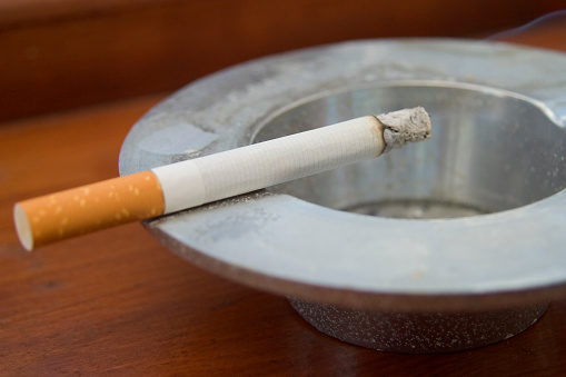 cigarette ashtray in open area, many butts in cigarette ashtray,