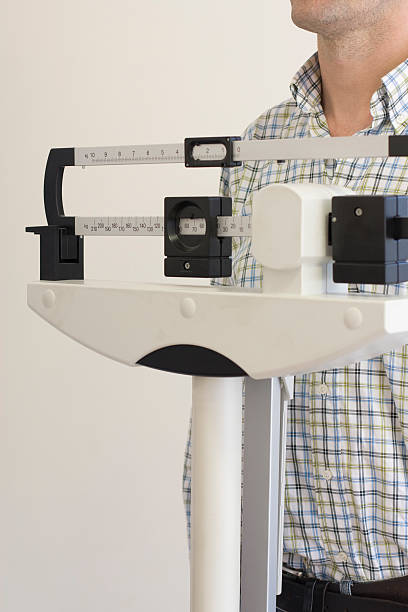 istock man on  medical weight scale 89479832