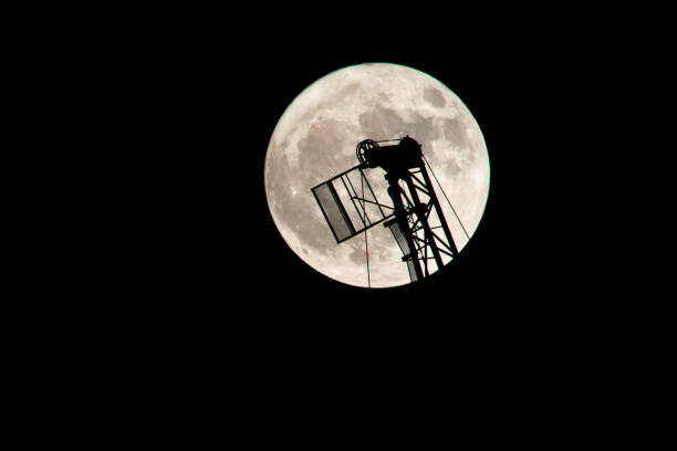 istock Construction crane against the background of the full moon. 894831018