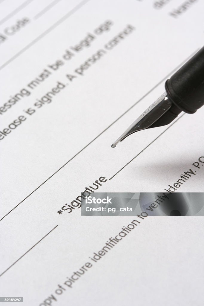 Close up of a document Close up of a hand signing a document. Focus is on the signature Agreement Stock Photo