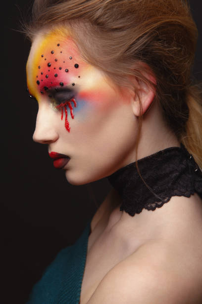 istock Young female model with bloody eyes makeup 894869848