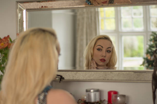 istock Attractive young girl admires herself in a mirror 894911028