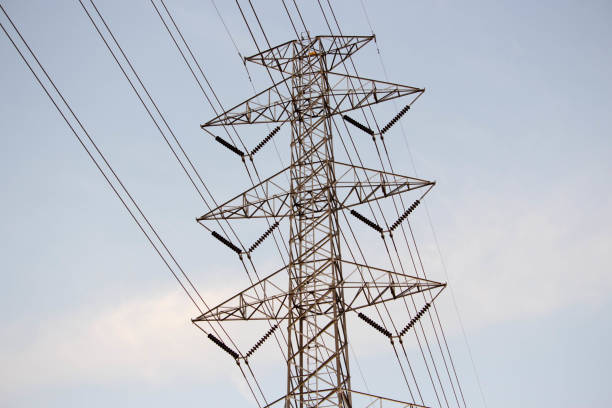 istock Electrical grid transmission power lines with wind turbines and sunset, and blue sky. high voltage pole in countryside 894922186