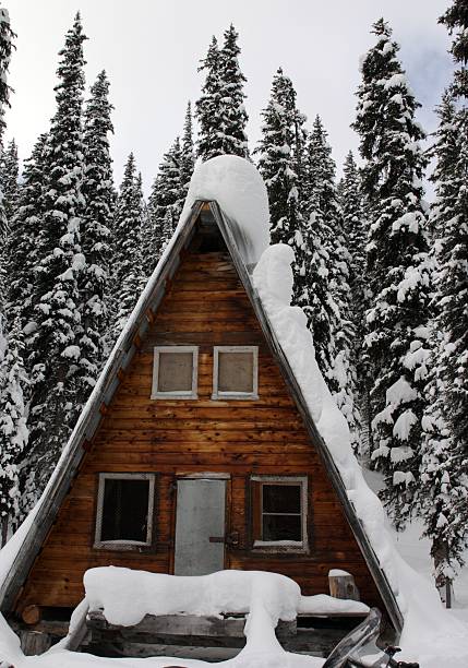 Minimal winter scene showing a house roof completely covered in snow with a small attic window and clear blue sky. Clean composition and large copy space make this image ideal for winter, home, insulation, real estate, energy efficiency, and seasonal concepts.