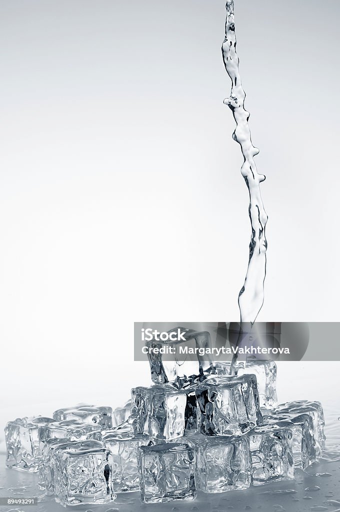 Transparente fresca Verter agua mineral en crystal cubos de hielo congelado. - Foto de stock de Agua potable libre de derechos