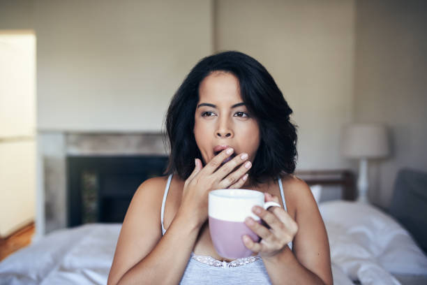buongiorno? no - yawning women drink coffee cup foto e immagini stock