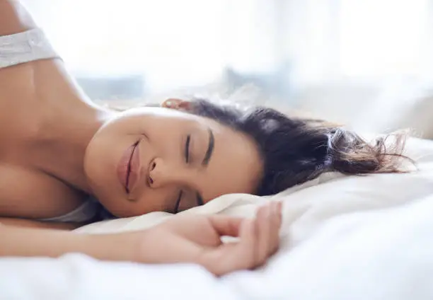 Shot of an attractive young woman relaxing on her bed in the morning at home