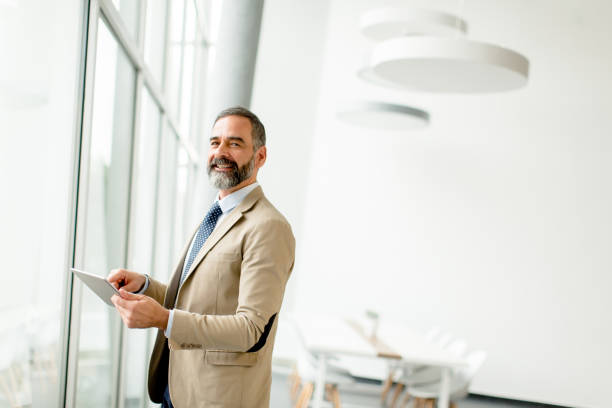 istock Middle aged  businessman with tablet in office 894946830