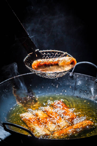 istock Fresh spring rolls frying in black pan 894949570