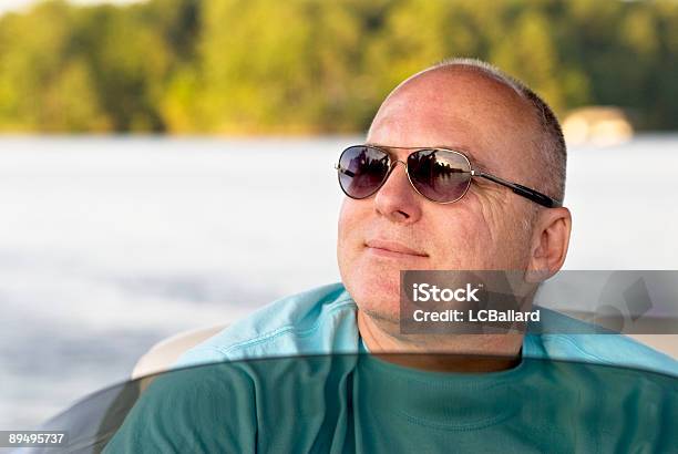 Mature Smiling Man Wearing Sunglasses Riding In A Pontoon Boat Stock Photo - Download Image Now