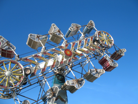 Shot of fun ride at a local midway park with blue sky backdrop.