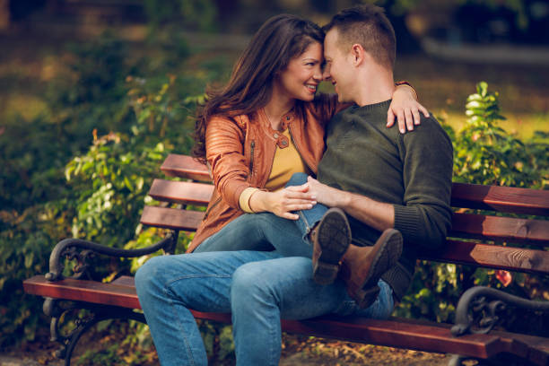 istock Embraced couple sitting on the bench in autumn park 894961924