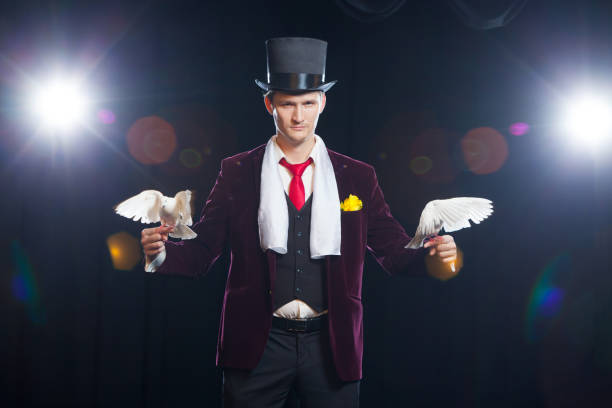 istock The magician with a two flying white Doves. on a black background 894962234