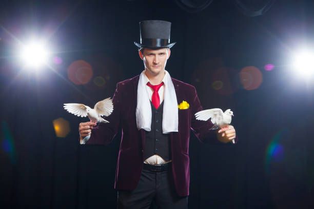 istock The magician with a two flying white Doves. on a black background 894962288