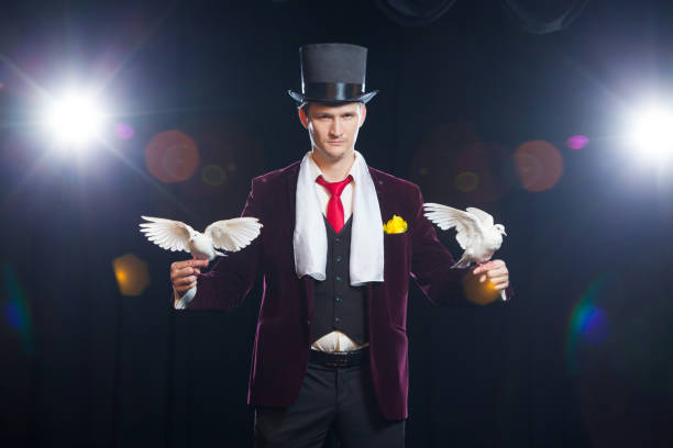 istock The magician with a two flying white Doves. on a black background 894962490