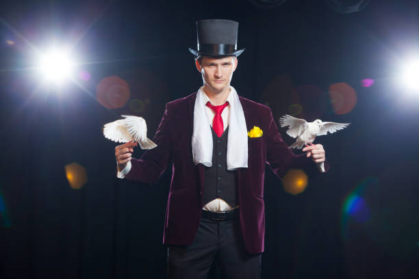 istock The magician with a two flying white Doves. on a black background 894962716